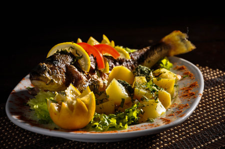 Plate of fried fish with potato and lemon