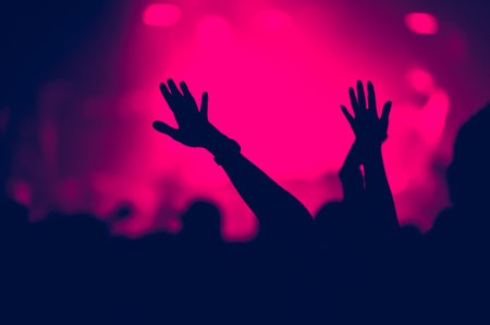 Crowd with outstreched arms applauding at concert