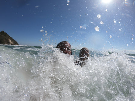 Ocean waves splashing on a romantic couple. Summer honeymoon conceptの写真素材