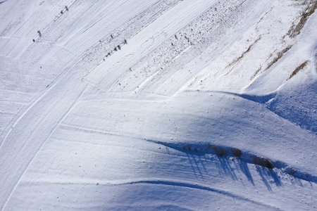 Aerial drone view of snow patterns and background. Snow covered countryside terraces in the mountainsの写真素材