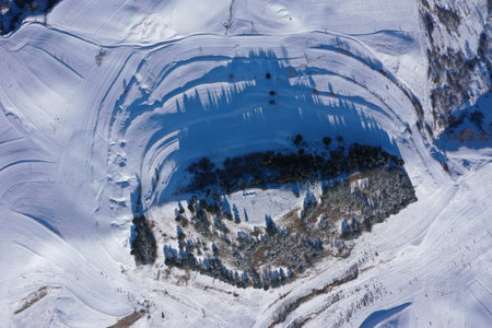 Aerial drone view of snow covered countryside hills with light snow