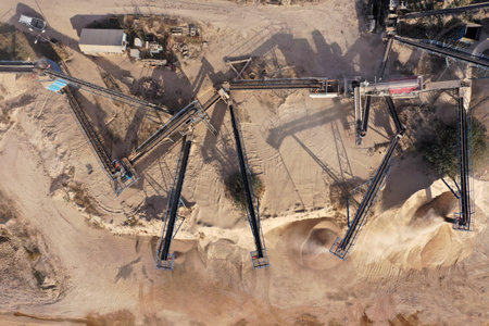 Aerial view of stone jaw crusher plant. Sand making plant and belt conveyor in mining quarry. Sand crushing and bulk materials for constructionの写真素材