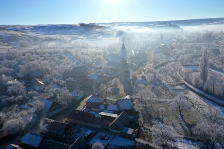 Morning sunrise lights and mist, fog over village church tower aerial drone viewの写真素材