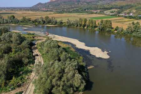 Aerial view of backhoes digging sand and gravel with shovels from the river by droneの写真素材