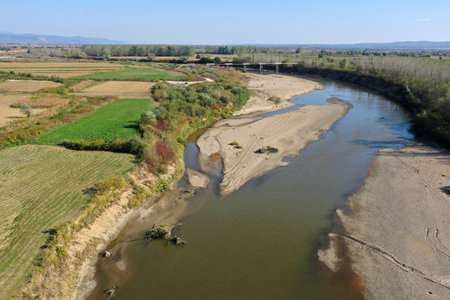 Flying over a river flowing on a plain aerial view by droneの写真素材
