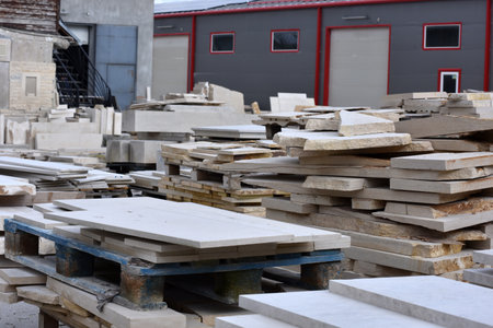 Workshop for the processing of stone products. Warehouse of decorative natural stone in the open air. Limestone cuttings for productionの写真素材
