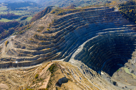 Flying above an open pit mine, copper excavation in Rosia Poieni, Romania. Aerial drone viewの写真素材