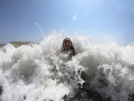 Powerful ocean waves splashing on child girl. Summer vacation conceptの写真素材