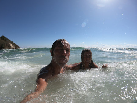 Powerful ocean waves splashing funny couple. Summer vacation conceptの写真素材