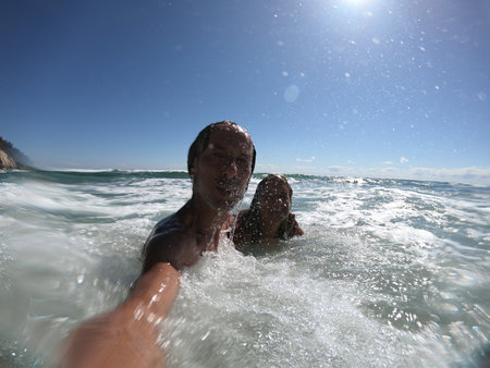 Sea waves splashing on happy couple. Just married conceptの写真素材