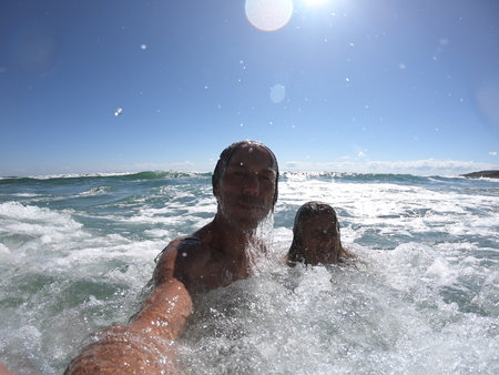 Sea waves splashing on happy couple. Just married conceptの写真素材