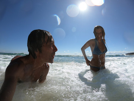 Ocean waves splashing on a romantic couple. Summer honeymoon conceptの写真素材