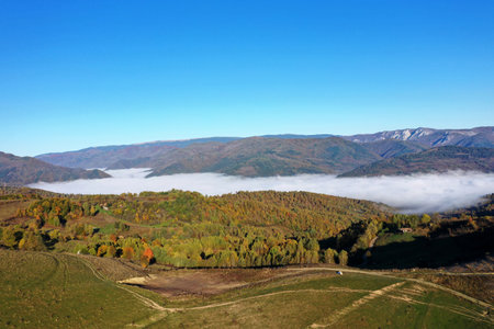 Aerial view of autumn morning mist and clouds in the valley by droneの写真素材