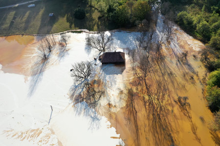 Aerial view of sinking village house in the middle of toxic acid mine drainage decanting pond. Geamana, Rosia Montana, Romaniaの写真素材