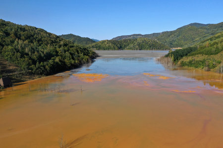 Aerial view of surreal natural patterns of gold cyanide leaching flowing into decanting lake by droneの写真素材