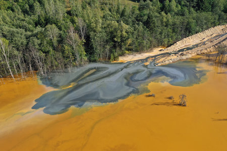 Flying over surreal patterns of flowing colorful mining chemical residuals aerial by droneの写真素材