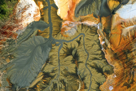 Aerial view of surreal natural patterns of gold cyanide leaching flowing into decanting lake by droneの写真素材
