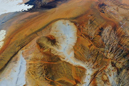 Aerial view of surreal natural patterns of gold cyanide leaching flowing into decanting lake by droneの写真素材