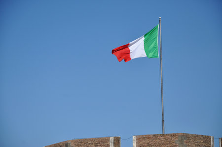 Flag of Italy waving against blue skyの写真素材