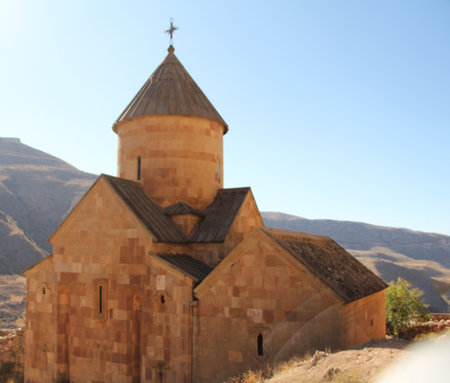 Old Stone Church Building With Mountains In The Background Under Clear Blue Sky