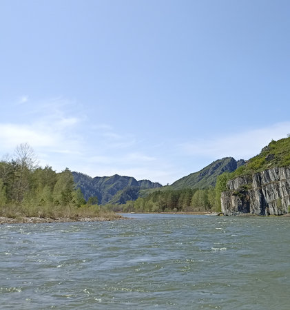 This breathtaking landscape showcases a powerful river winding through rugged mountains, featuring striking rock formations and lush greenery, perfect for nature lovers and outdoor enthusiasts.の写真素材
