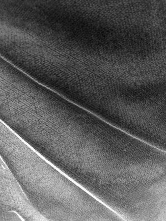 Close-up of gray denim fabric texture. Seamless background of cotton material with a detailed surface and diagonal folds. Perfect for creative designs and textile backgrounds.の写真素材