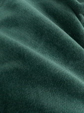 Close-up of deep green velvet fabric texture. Ideal for backgrounds and designs needing a touch of luxury and elegance. Perfect for fashion, textiles, and creative projects.の写真素材