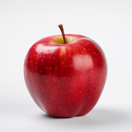 A fresh, ripe red apple with water droplets on a white background. This image symbolizes healthy eating and nutrition, perfect for advertising and food-related designs.の素材
