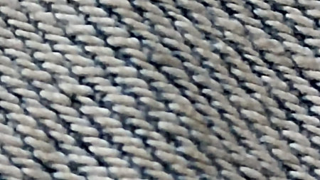A close-up shot highlighting the intricate texture of woven fabric. The pattern blends light and...