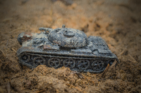 Rusty burned-out military tank in the rain. Childrens toyの写真素材