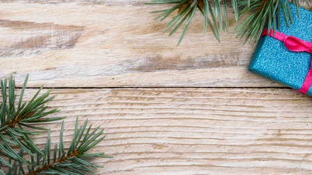 Christmas gifts, fir tree branches on white wooden background. Flat lay, frame. Christmas composition.の写真素材