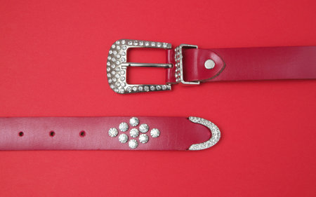 leather belt on red backgroundの写真素材