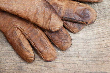 Old working gloves on wooden table, construction toolsの写真素材