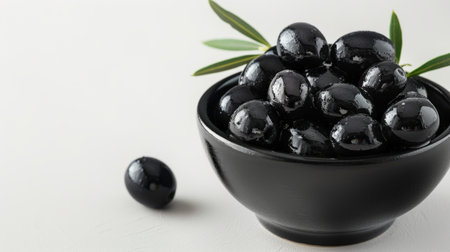 Black olives in a bowl on a white background. Copyspace.の素材