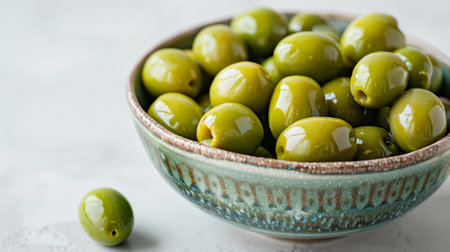 Green olives in bowl on white background, copy space for textの素材