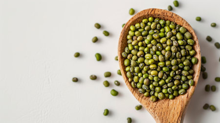 Mung beans in wooden spoon on white background, copy space.の素材