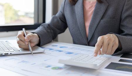 Accounting businesswomen are calculating income-expenditure and analyzing real estate investment data, Dedicated to the progress and growth of the company, Financial and tax systems concept.の写真素材
