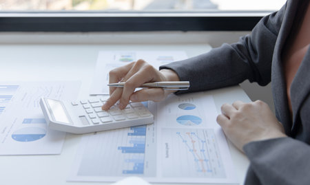 Accounting businesswomen are calculating income-expenditure and analyzing real estate investment data, Dedicated to the progress and growth of the company, Financial and tax systems concept.の写真素材