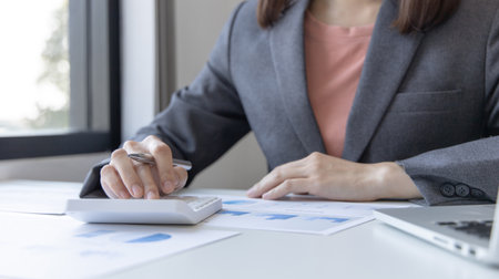 Accounting businesswomen are calculating income-expenditure and analyzing real estate investment data, Dedicated to the progress and growth of the company, Financial and tax systems concept.の写真素材