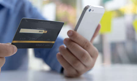 Businessman use mobile phones to register for security Online with a credit card to buy products...