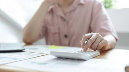 Accounting businesswomen are calculating income-expenditure and analyzing real estate investment data, Dedicated to the progress and growth of the company, Financial and tax systems concept.の写真素材