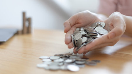 Woman's hand full of coins, Business people saving money for future investment, saving money, Silver baht coins,Finance and investment, including taxes, Spending money like maturity concept.の写真素材