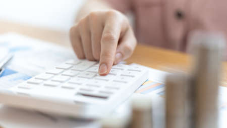 Accounting businesswomen are calculating income-expenditure and analyzing real estate investment data, Dedicated to the progress and growth of the company, Financial and tax systems concept.の写真素材