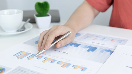 Asian women are analyzing graphs, market data and assessing investment risks, Working at home during...
