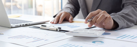Business men are calculating real estate investment expenditures and analyzing the company's...