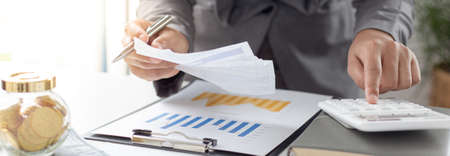 Business men are calculating real estate investment expenditures and analyzing the company's...