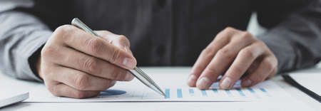 Businessmen analyze market data and calculate the cost of buying-selling products for a client's company, Professional marketing and financial accountants concept.の写真素材