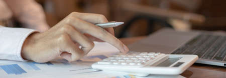 Business men are calculating real estate investment expenditures and analyzing the company's finances in line with the global economy, Analysis of financial accounting and real estate investment concept.の写真素材