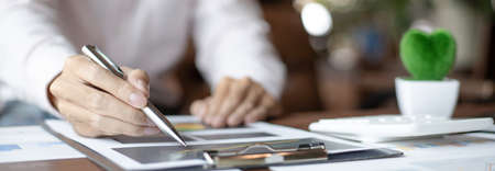 Business men analyze financial graphs and find break-even points for investments in order to reduce costs and reduce corporate taxes, Analysis of financial accounting and real estate investment concept.の写真素材