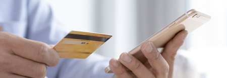 Young Asian businessman uses a credit card to shop online via laptop in his office, Buy online, Shopping Online concept.の写真素材